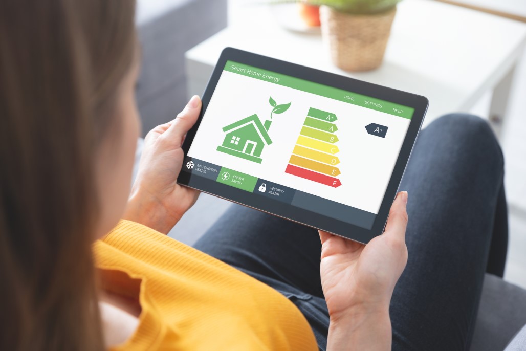 Energy efficiency mobile app on screen, eco house stock photo. Photo credit: iStock/simpson83.