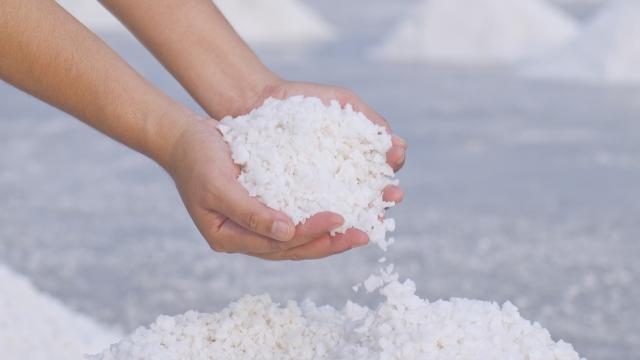 A pair of hands scooping salt.